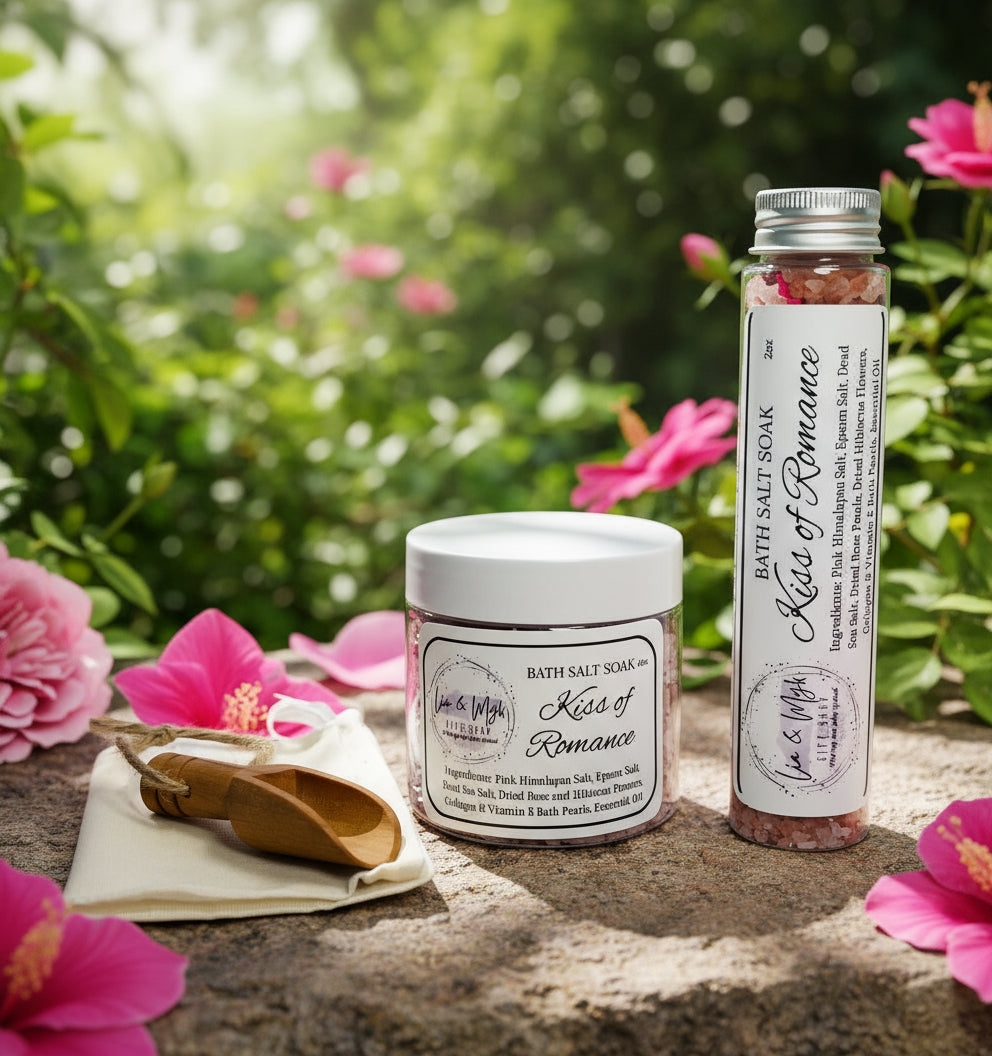 Bath salt products with 'Kiss of Romance' label with rose and hibiscus petals.